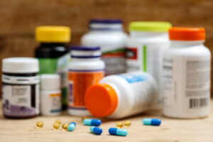 Medication bottles sit on a counter with loose pills sitting in front.