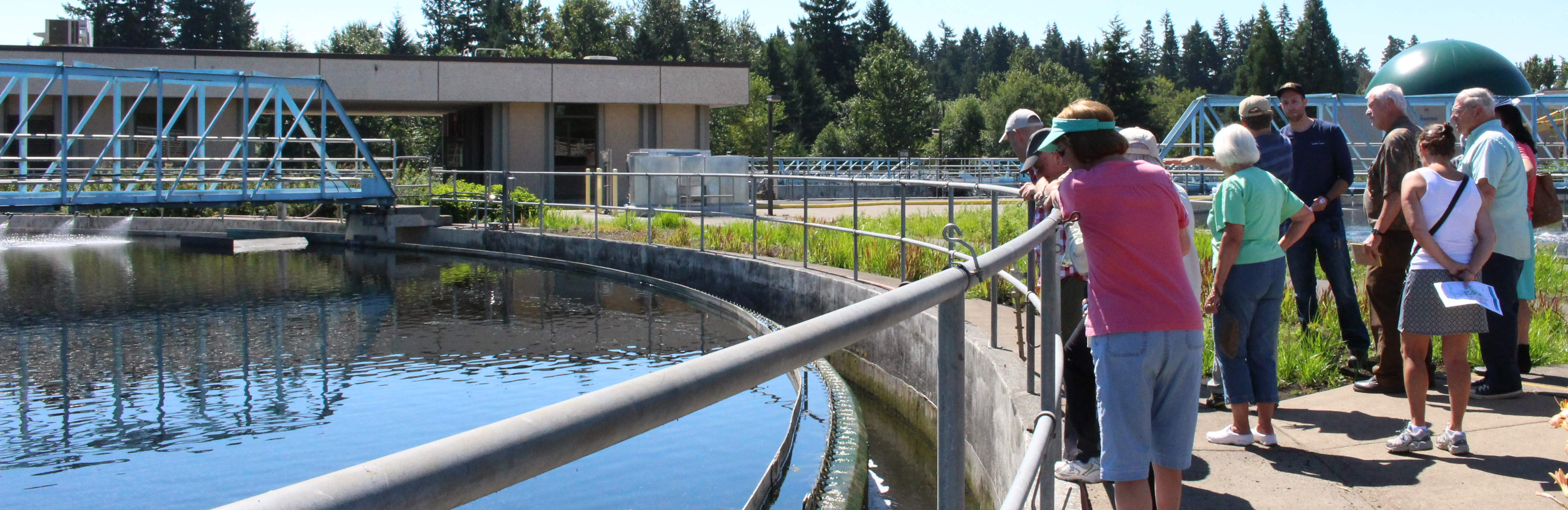 A group of community members look into the clarifier at Durham during a facility tour.
