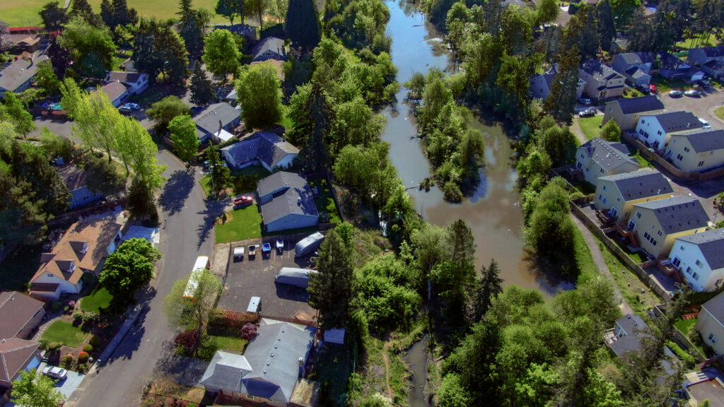 An overhead image of a neighborhood next to a creek.